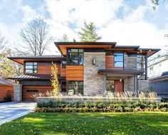 a large modern house with lots of windows and wood trimmings on the front