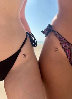 two women in bikinis standing next to each other with tattoos on their butts