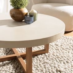 a coffee table with a potted plant sitting on it's top in a living room