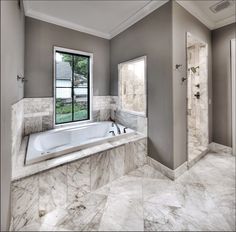 a large bathroom with marble floors and walls