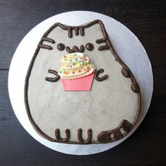 a cake decorated to look like a cat holding a cupcake