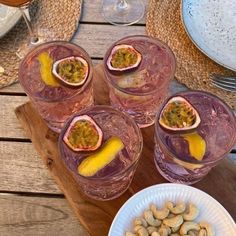 three glasses filled with different types of food on top of a wooden table next to plates and utensils