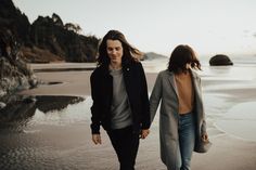 two people walking on the beach holding hands