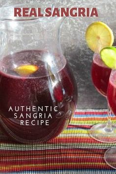 there is a pitcher and two glasses filled with sangria next to each other on the table