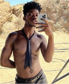 a shirtless man taking a selfie with his cell phone