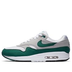 The Nike Air Max 1 Anniversary "Evergreen" is a special edition of the groundbreaking silhouette that introduced visible Air cushioning to the world back in 1987. This release features OG-inspired color blocking, with a breathable white mesh upper and grey synthetic suede overlays. The dark green mudguard is a nod to the classic Nike colorway, and is repeated on the signature Swoosh and branding hits at the heel panel and tongue tag. If you're a fan of the Air Max 1, or just want a clean and com Back In 1987, 1 Anniversary, Nike Air Max 1, 1st Anniversary, Comfortable Sneakers, White Mesh, Air Max 1, To The World, Air Max