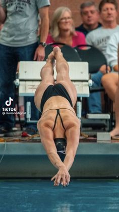 a woman diving into the pool while people watch