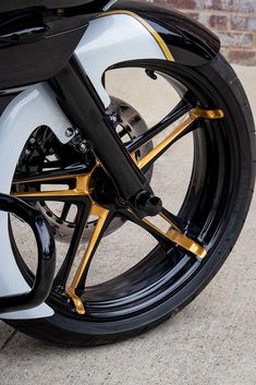 the front wheel of a black and gold motorcycle