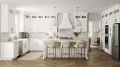 a large kitchen with white cabinets and wood flooring, along with an island in the middle