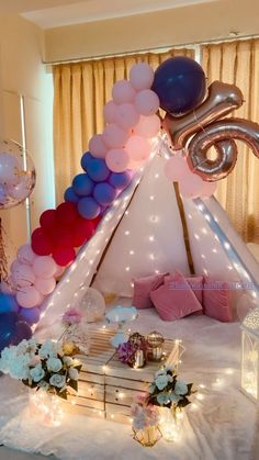 a teepee tent with balloons and lights on it