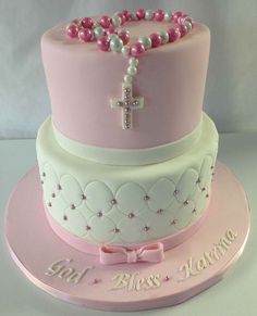 a pink cake with pearls and a cross on top is for pint to pin it