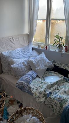 an unmade bed sitting in front of a window