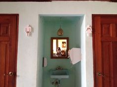 a bathroom with green walls and wooden doors