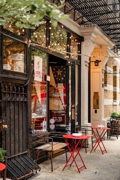 an outdoor cafe with red tables and chairs