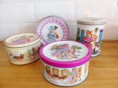 three tins are sitting on the counter next to each other, one is decorated with cartoon characters