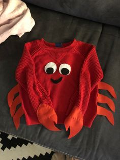 a red crab sweater sitting on top of a couch