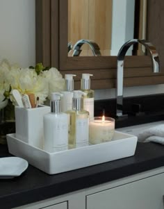 a bathroom counter with candles and soaps on it