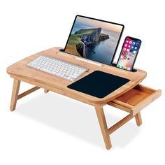 a wooden desk with a laptop, keyboard and phone on it next to a mouse pad