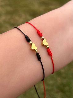 two gold hearts on red string bracelets