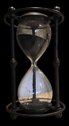 an hourglass sitting on top of a metal stand with a clock in the middle