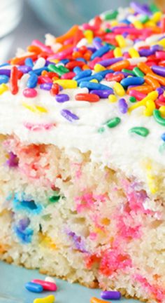 a piece of cake with white frosting and sprinkles