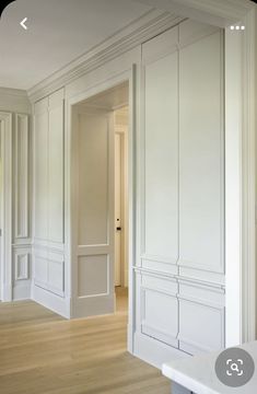 an empty room with white walls and wood floors