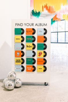 a poster with some balls on the ground in front of it that says find your album