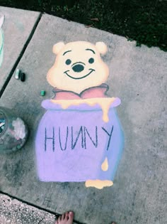 someone's feet are standing next to a chalk drawing of winnie the pooh