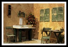 an old fashioned kitchen with green shutters on the windows and a sink in the center