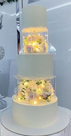 three tiered wedding cake with flowers and lights