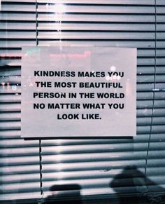 a sign posted on the side of a window that says, kindness makes you the most beautiful person in the world no matter what you look like