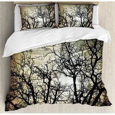 a bed with two pillows on top of it and trees in the background at night