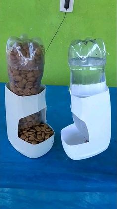 two plastic containers filled with food sitting on top of a blue table next to a green wall