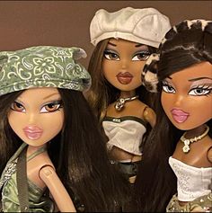 three dolls are posed next to each other with hats on their heads and one has her tongue out