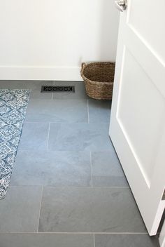 a bathroom with a blue rug on the floor and a white door in the corner