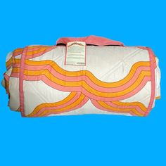 an orange and pink duffel bag on a blue background