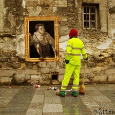 a man in yellow is sweeping the floor next to a painting with a woman on it