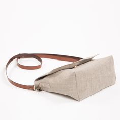 This small size linen bag has been designed for lovers of simplicity. It's a crossbody or shoulder linen bag, with long adjustble vegan leather strap. Handmade with a rustic linen in neutral color. A lightweight fabric bag perfect for everyday use. Small summer messenger bag with lid. Made from textured linen in taupe color, it's not rigid. The size is just to hold your essential. Lined with cotton fabric, pockets on both sides, one with zipper and the other double slip pocket. Closed with zippe Simple Beige Crossbody Shoulder Bag, Minimalist Beige Crossbody Satchel, Linen Tote Shoulder Bag, Linen Tote Shoulder Bag For Daily Use, Brown Linen Shoulder Bag For Daily Use, Everyday Linen Tote Shoulder Bag, Linen Shoulder Bag For Daily Use, Natural Linen Shoulder Bag For Everyday Use, Everyday Linen Canvas Bag