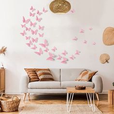 a living room filled with furniture and lots of pink butterflies on the wall above it