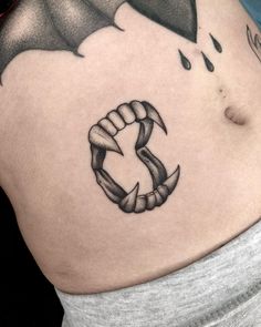 a black and white photo of a woman's stomach with a dragon tattoo on it