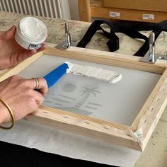 a person is using a paint roller to fix the bottom part of an unfinished drawer