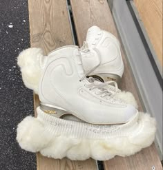 a pair of white shoes sitting on top of a wooden bench