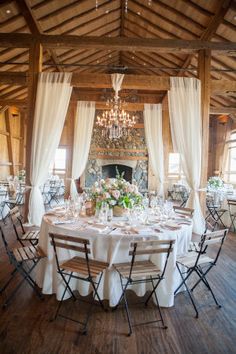 a dining room set up for a formal function with white linens and drapes