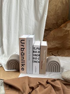 two books sitting on top of each other next to a pile of paper and rocks