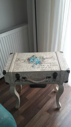 an ornately decorated coffee table in the corner of a room with a blue chair