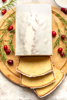 slices of bread with icing and cranberries on a cutting board