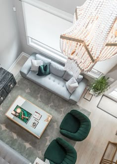 an overhead view of a living room with couches, chairs and a chandelier