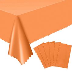 an orange tablecloth with scalloped edges and matching placemats on top