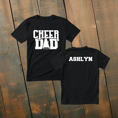 Custom Cheer Dad Shirt Make a statement of support with our custom cheer dad t-shirts! Available in various colors and sizes, these shirts are designed to be a perfect fit for any cheer dad. Personalize it with their name to make it truly one-of-a-kind. Wear it to cheer events, practices, or simply around town, and showcase your love and pride as a cheer dad! *Deets* *This custom shirt is handmade with professional vinyl. *Our shirts are unisex and are true to size! *In the photo's you will be able to see the custom options in regards to color that you may choose from. *We use 100% cotton shirts. The glitter material does not wash off and will last through multiple washes.  *If your shirt color is out of stock we will contact you as soon as possible to see if you would like to change shirt Cheer Parent Shirts Design, Dad Shirt Ideas, Cheer Mom And Dad Shirts, Cheer Dad Shirt Ideas, Customizable Casual T-shirt For Cheerleading, Cheer Dad Shirt, Custom Print T-shirt For Cheerleading, Cheer Dad Shirts, Cheerleading Picture Poses