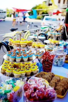 a table filled with lots of cupcakes and muffins